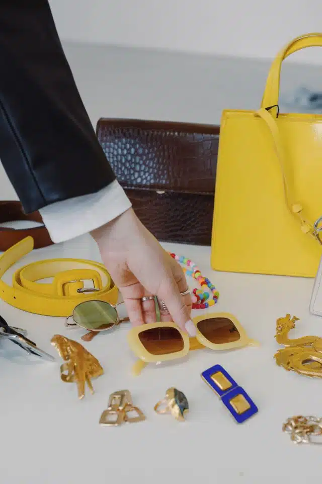 Sophisticated layout of fashion accessories including handbags and sunglasses on a table.